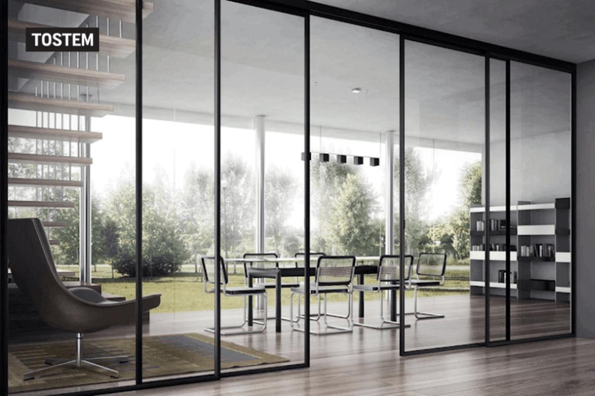 Vách ngăn nhôm kính cửa lùa TOSTEM phân chia văn phòng với khu vực showroom tiện lợi.