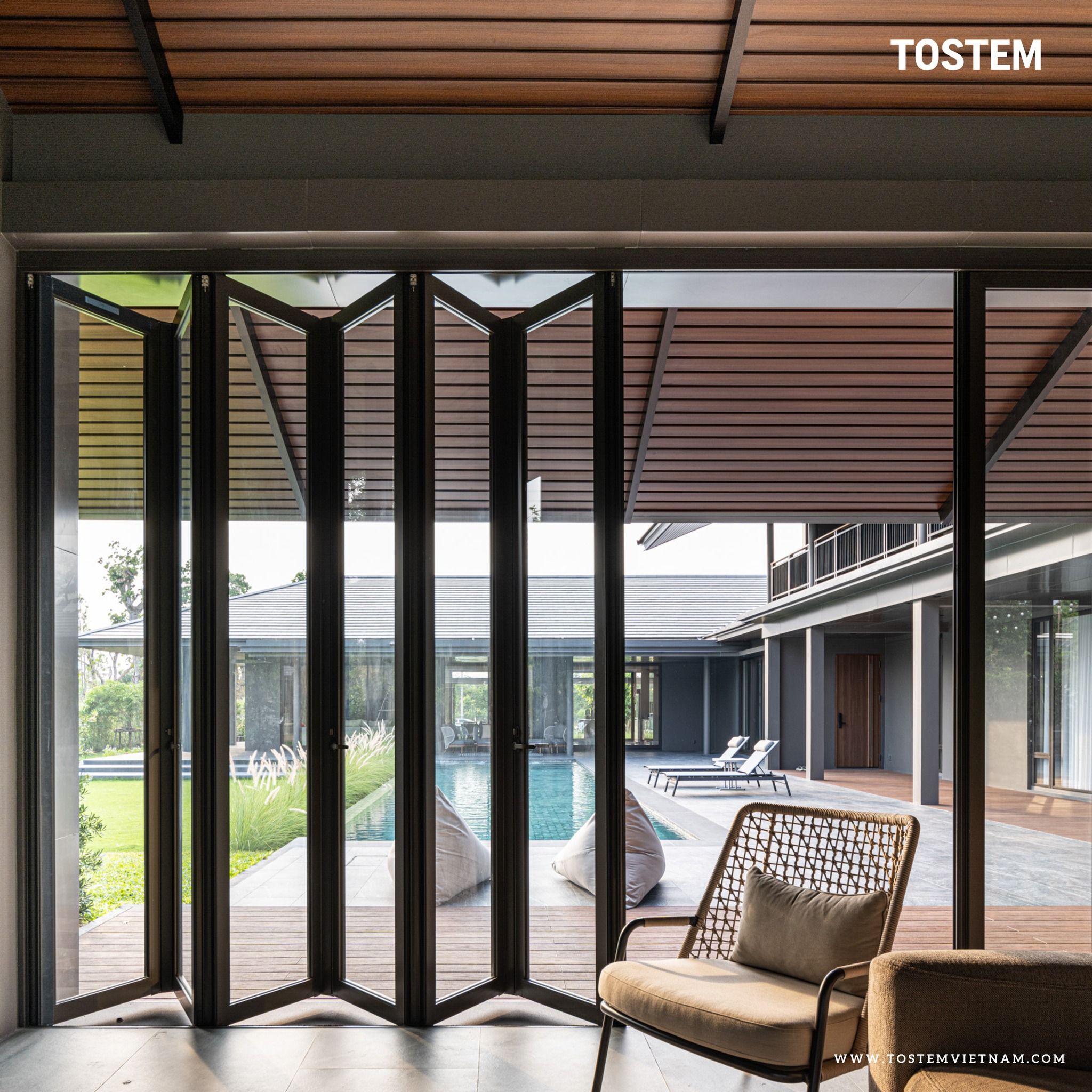 Cửa đi nhôm kính trong suốt dạng mở xếp trượt TOSTEM sở hữu cơ chế chống kẹp tay an toàn, đảm bảo an toàn trẻ nhỏ