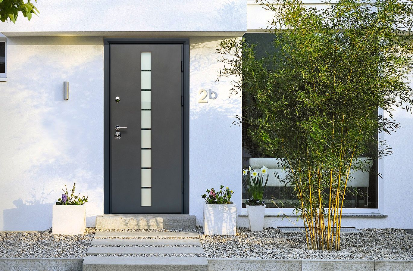 Cửa chính 1 cánh tích hợp các ô kính mờ, tạo chiều sâu cho mặt tiền