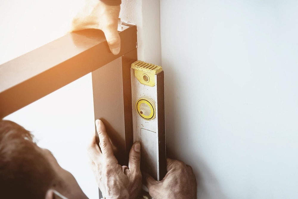 Sử dụng thước nivo để kiểm tra và căn chỉnh khung cửa cho vuông góc