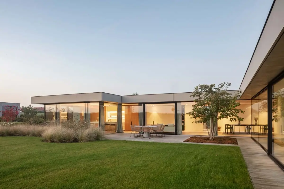 Nhà cấp 4 chữ L mái bằng với cây xanh và bàn tiệc ngoài trời