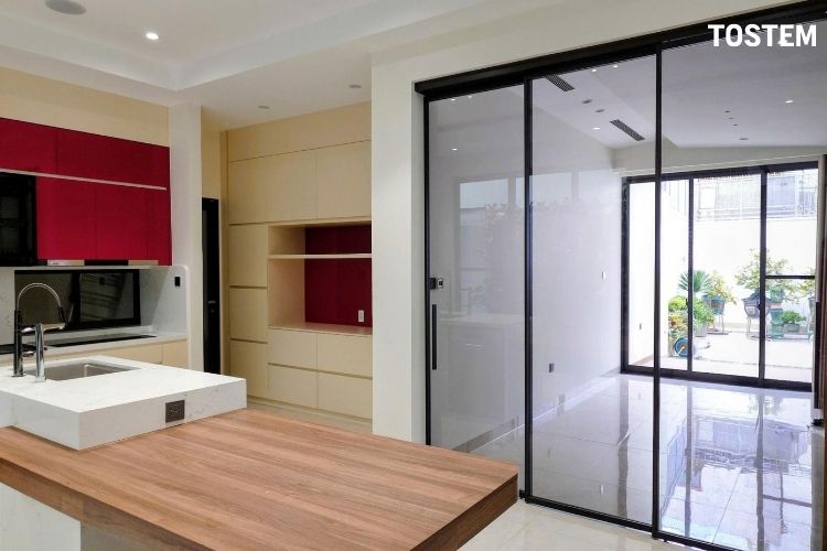 Vách kính ngăn phòng khách và bếp giúp hạn chế bám mùi thức ăn và phân chia không gian